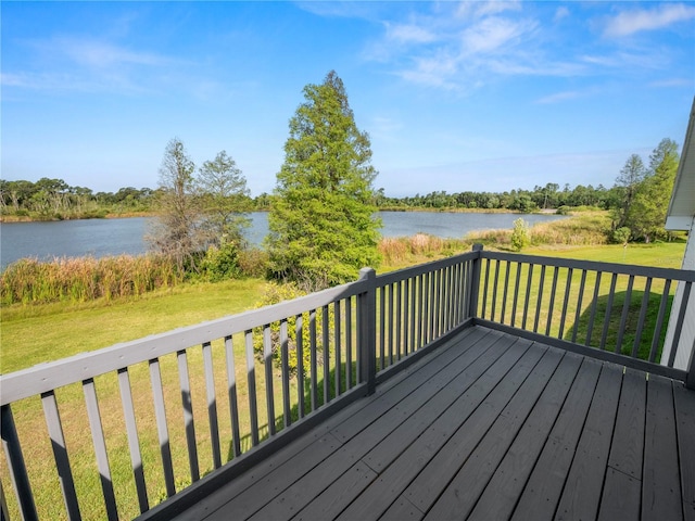 wooden terrace with a water view and a yard