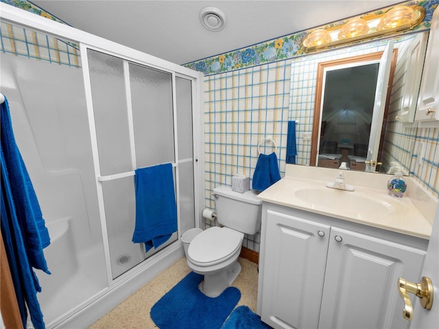 bathroom featuring a shower with door, tile walls, toilet, and vanity