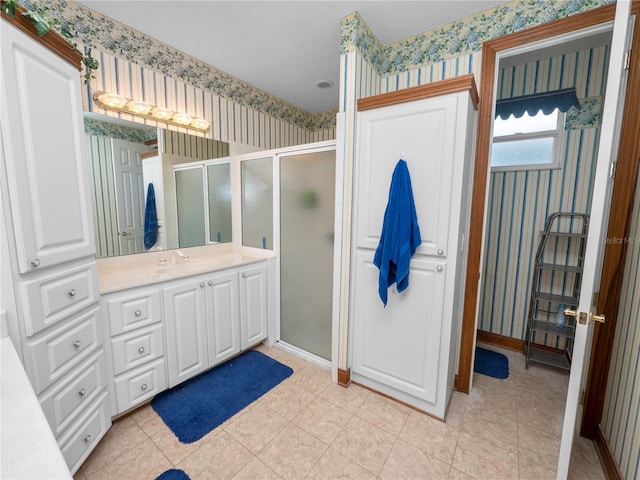 bathroom featuring tile floors, large vanity, and a shower with shower door