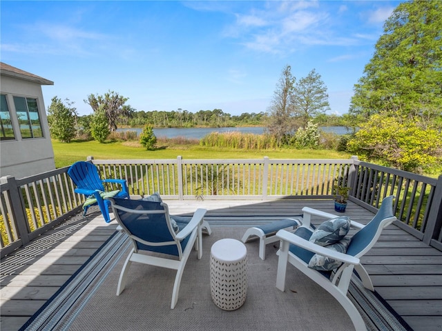 wooden deck with a water view and a lawn