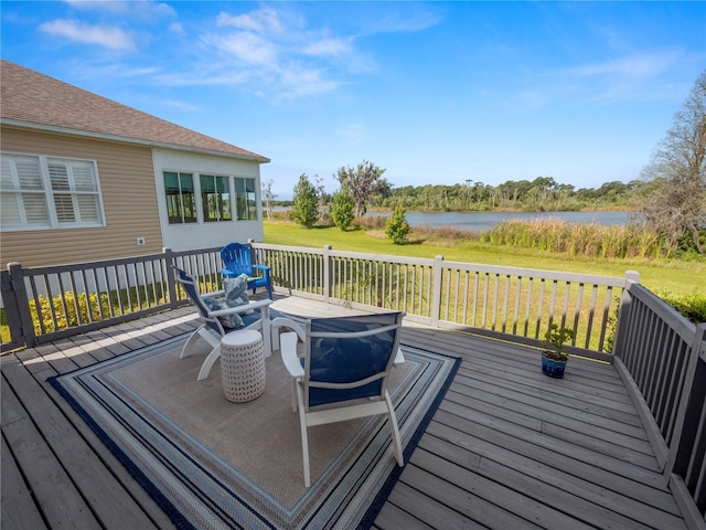 wooden deck with a water view and a lawn