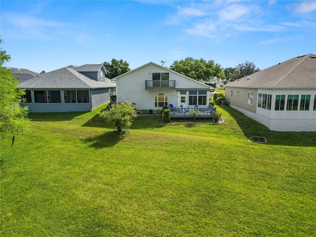 rear view of property featuring a sunroom and a lawn