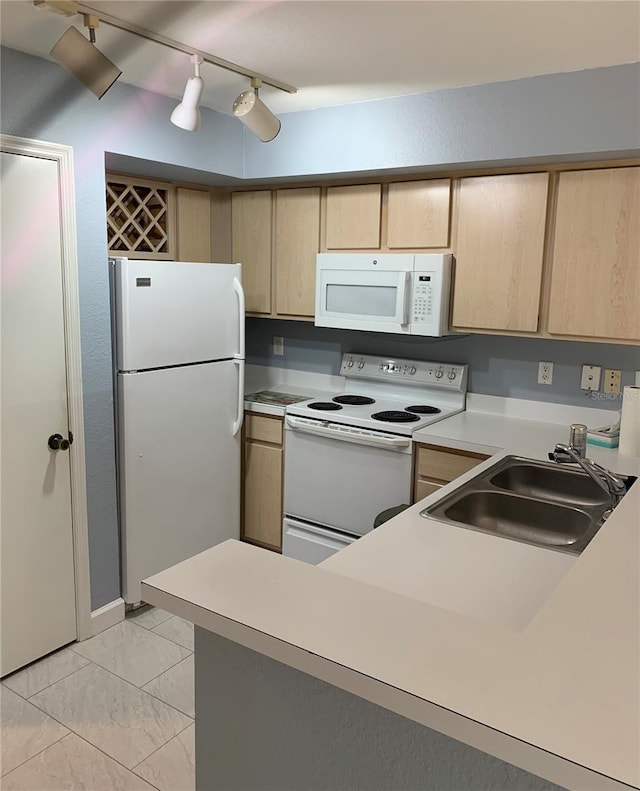 kitchen featuring light brown cabinets, light tile flooring, white appliances, track lighting, and sink