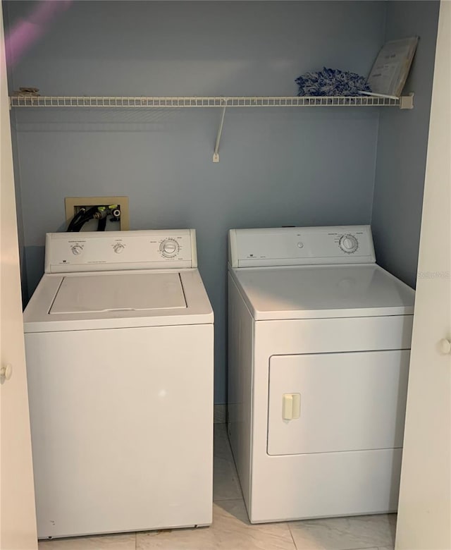 laundry area with light tile floors, washing machine and clothes dryer, and hookup for a washing machine