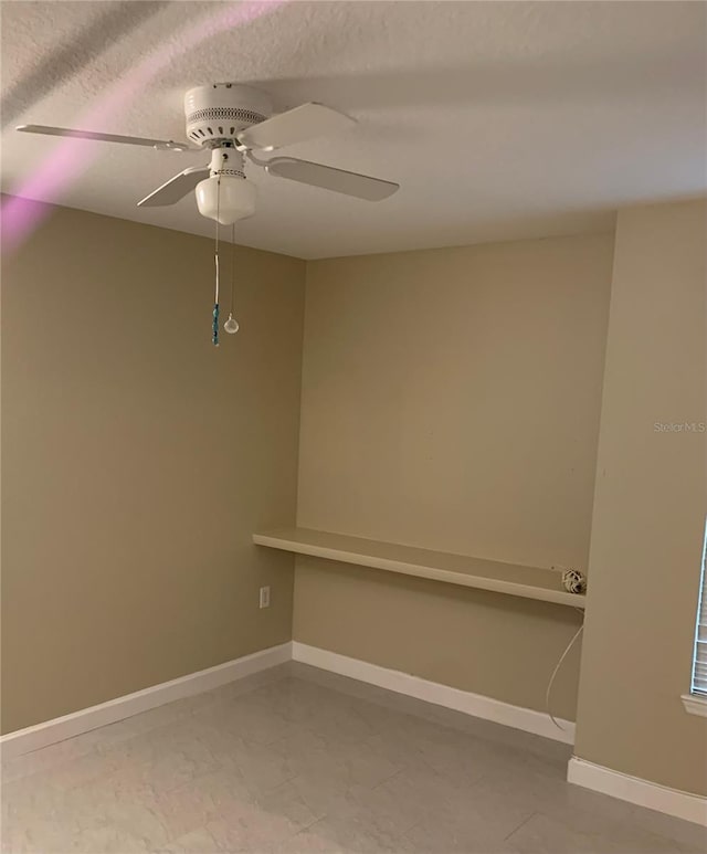 spare room with light tile floors and ceiling fan