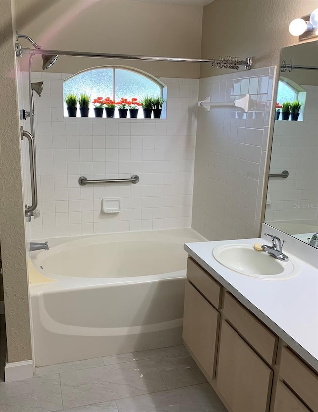 bathroom featuring tile flooring, vanity with extensive cabinet space, and tiled shower / bath