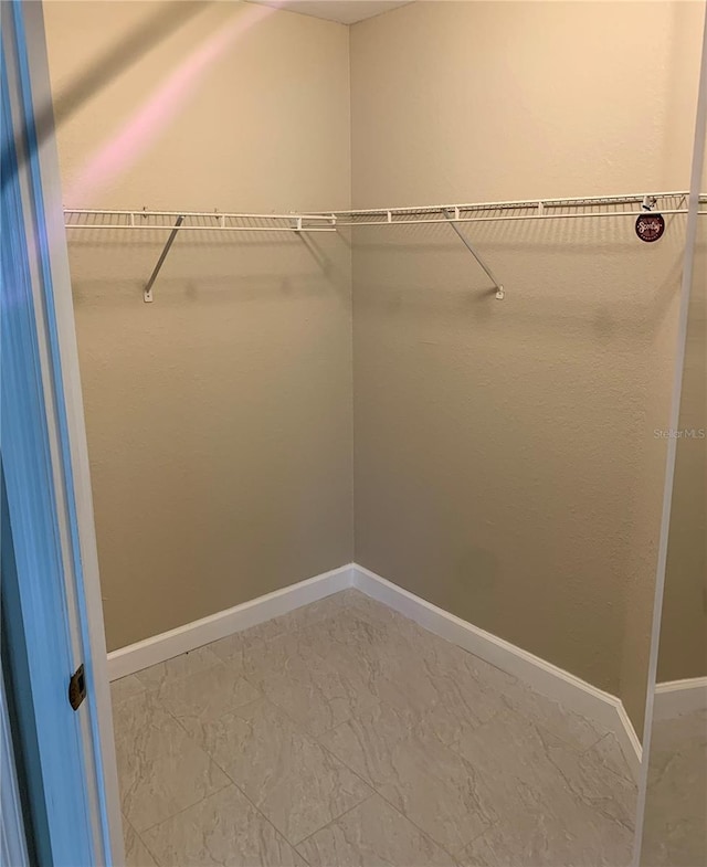 walk in closet with tile floors