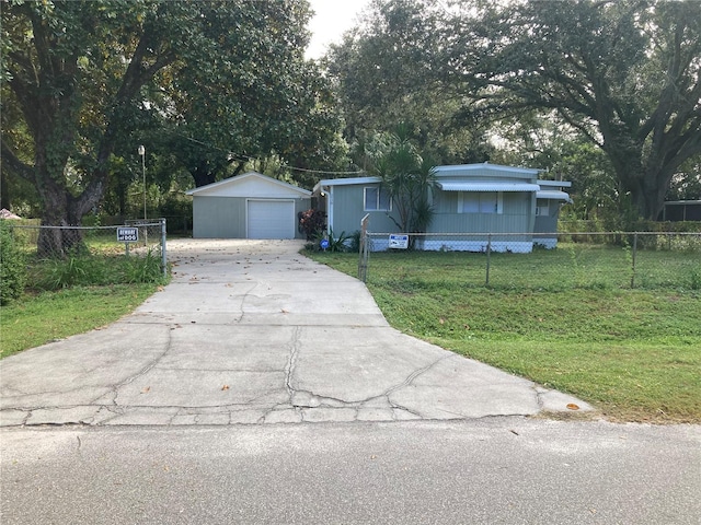 view of front of home with a garage, an outbuilding, and a front yard