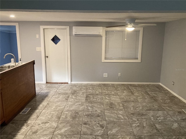 unfurnished bedroom featuring ceiling fan, sink, and a wall mounted air conditioner