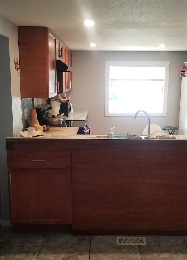 kitchen with stove and a textured ceiling