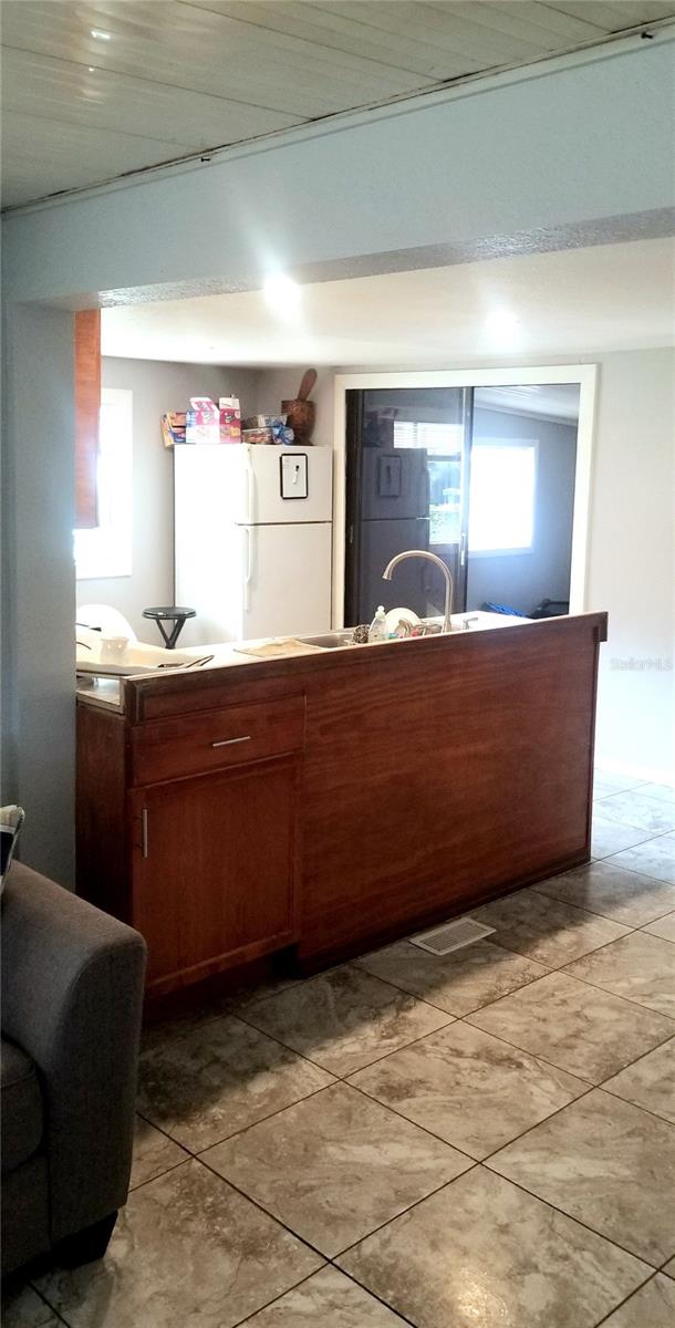 kitchen featuring white fridge, light tile patterned floors, a wealth of natural light, and fridge