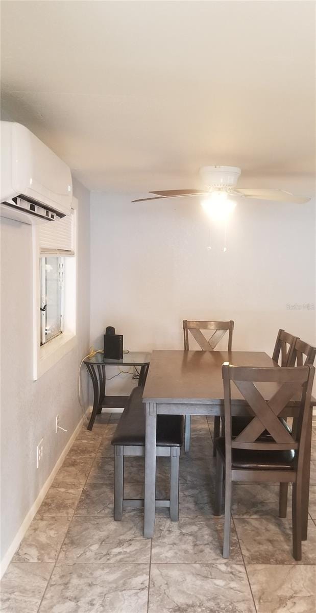 dining area with ceiling fan and a wall unit AC