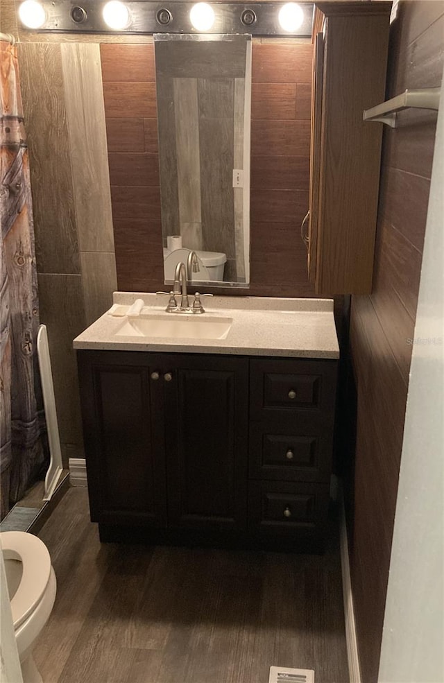 bathroom with a shower with curtain, vanity, toilet, and wood-type flooring