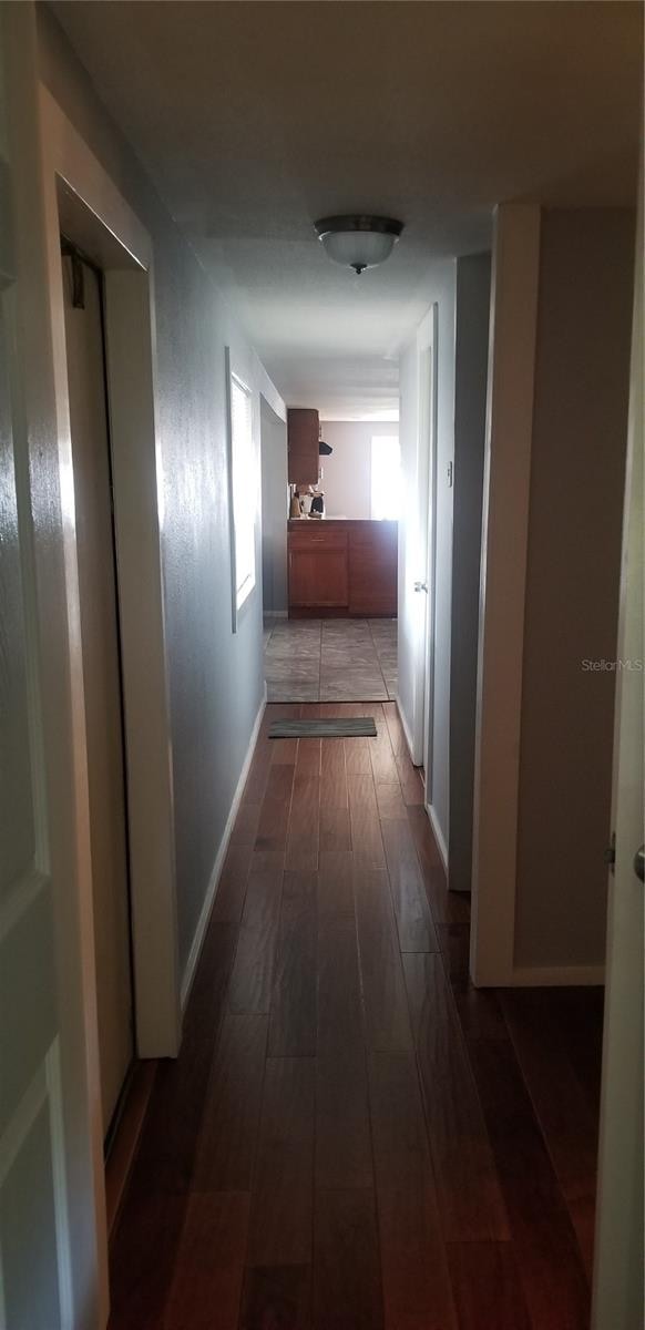 corridor with dark hardwood / wood-style flooring