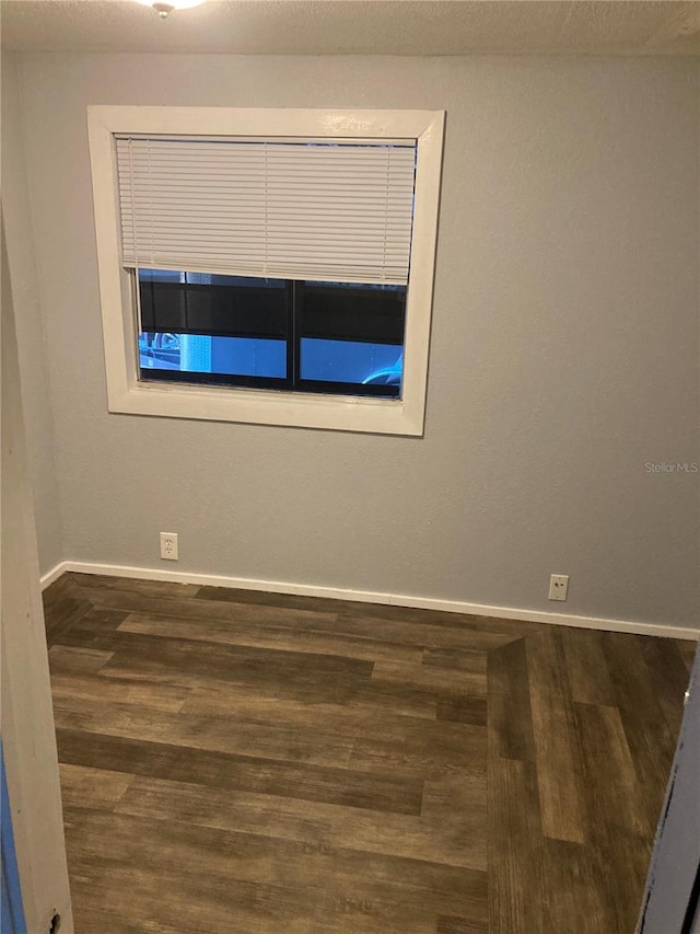 empty room featuring dark wood-type flooring