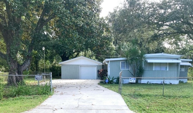 view of front of property featuring a garage, an outbuilding, and a front lawn