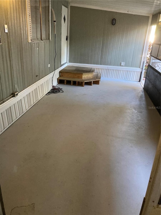 interior space with concrete flooring and wooden walls