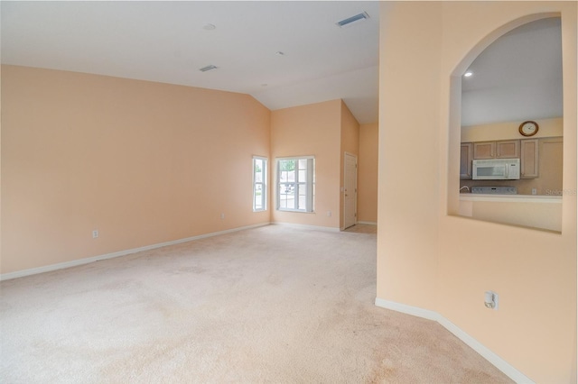 unfurnished room featuring light carpet and lofted ceiling