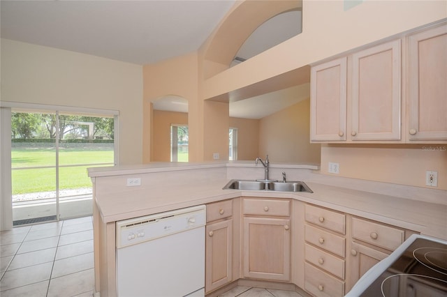 kitchen with light tile flooring, white dishwasher, light brown cabinetry, and sink