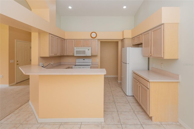 kitchen featuring light brown cabinetry, kitchen peninsula, white appliances, light tile floors, and high vaulted ceiling