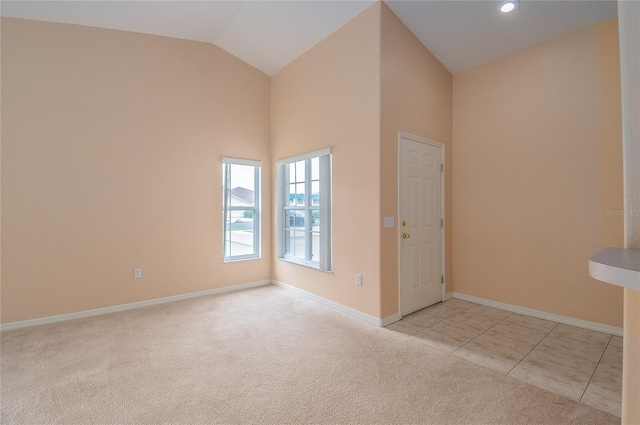 tiled spare room featuring lofted ceiling