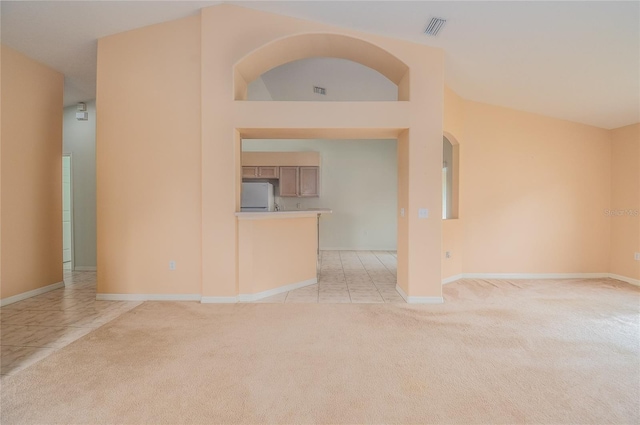 empty room featuring light colored carpet and lofted ceiling