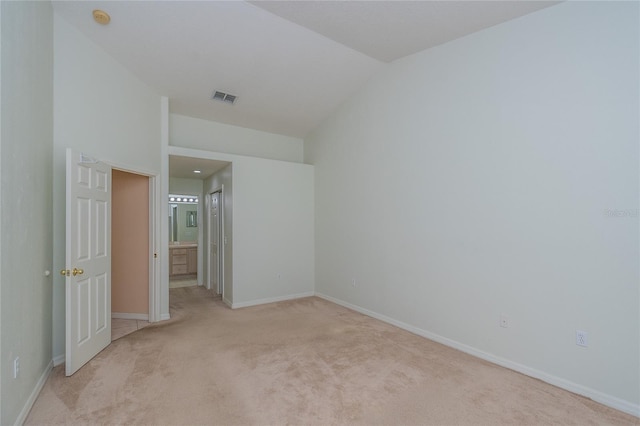 unfurnished bedroom with light carpet and lofted ceiling