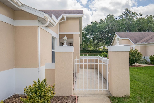 view of gate with a yard