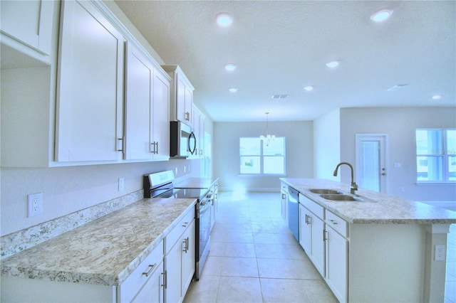 kitchen featuring white cabinetry, sink, stainless steel appliances, an island with sink, and pendant lighting