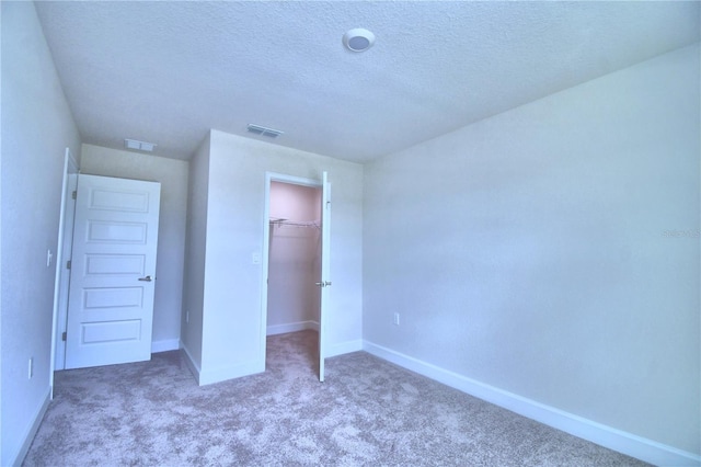 unfurnished bedroom featuring a closet, carpet, and a textured ceiling