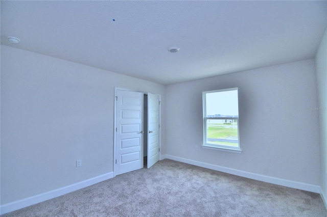 unfurnished room with light colored carpet