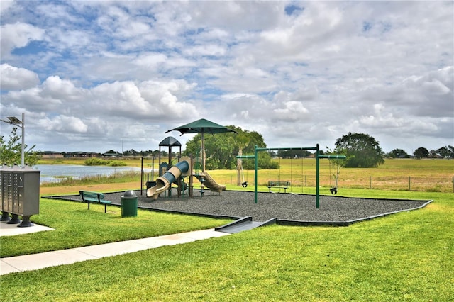 view of jungle gym featuring a yard and a water view