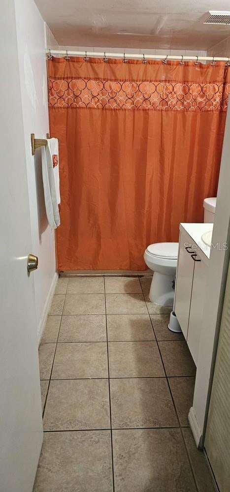 bathroom featuring toilet, tile floors, and vanity