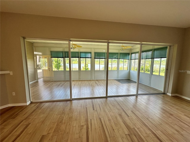 spare room featuring a wealth of natural light, ceiling fan, and light wood-type flooring