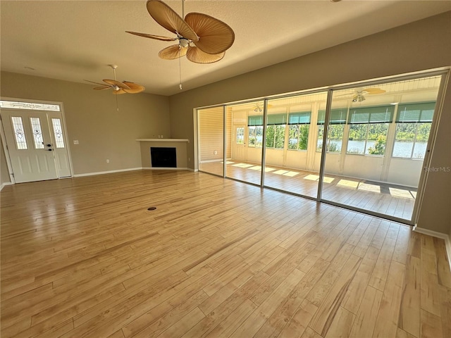 spare room with a healthy amount of sunlight, light hardwood / wood-style flooring, and ceiling fan