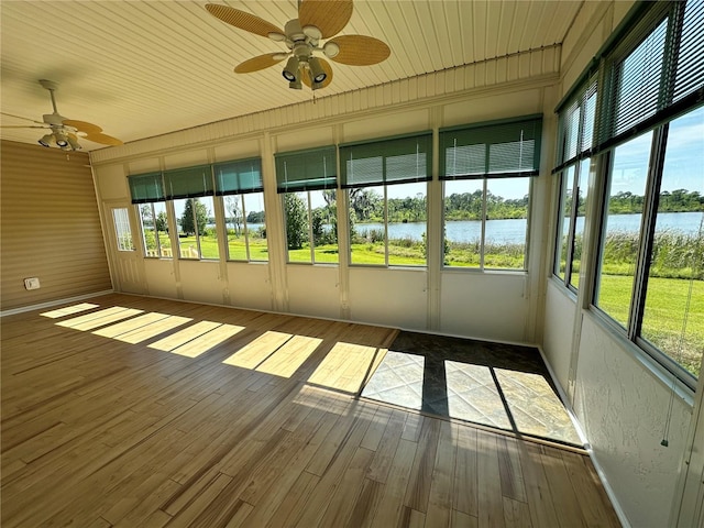 unfurnished sunroom featuring a healthy amount of sunlight, wood ceiling, a water view, and ceiling fan