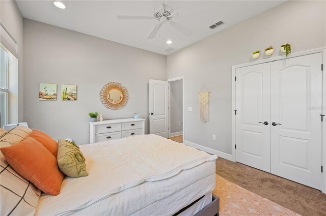 bedroom featuring light carpet, a closet, and ceiling fan