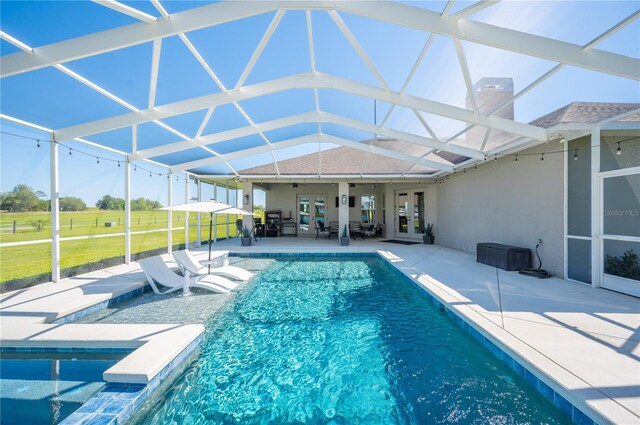 view of swimming pool featuring a lanai and a patio area