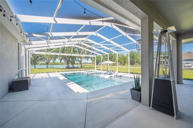 view of swimming pool with a water view, a patio, glass enclosure, and a yard