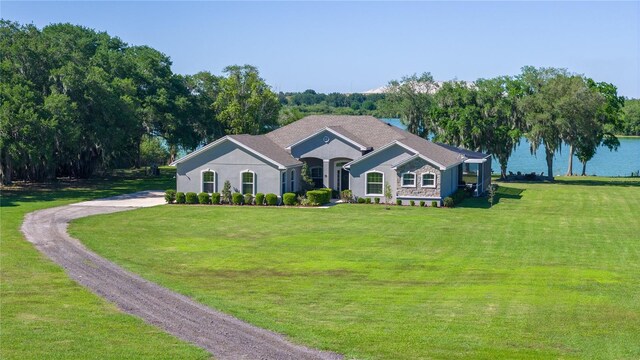 ranch-style home with a front yard and a water view