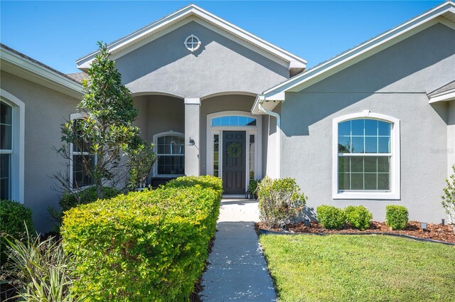 doorway to property with a lawn