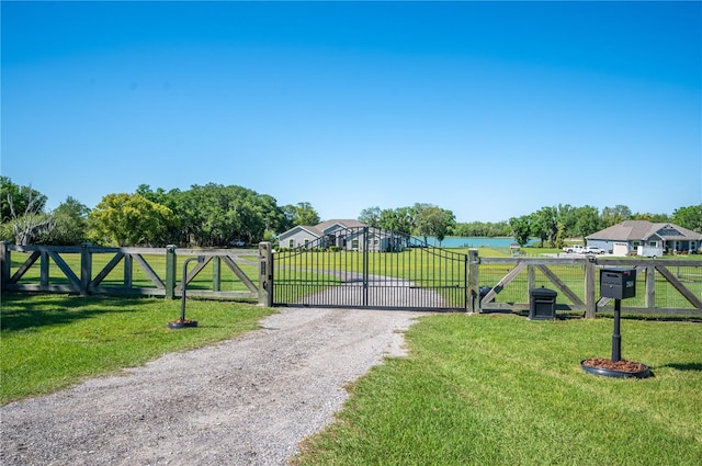 view of gate featuring a lawn and a water view