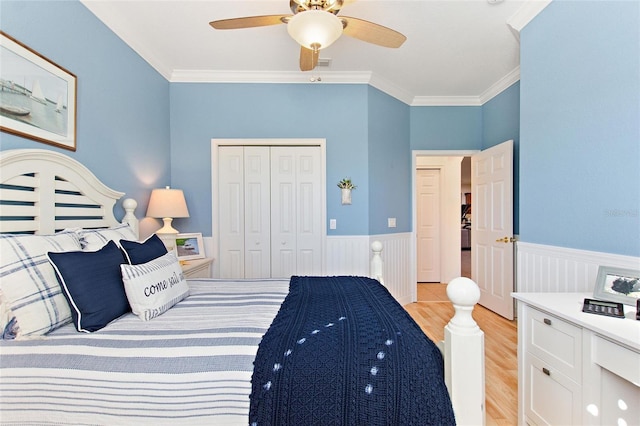 bedroom featuring ceiling fan, a closet, light hardwood / wood-style flooring, and crown molding