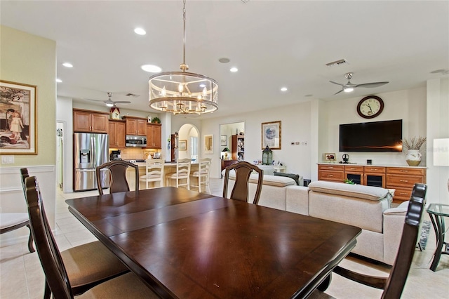 dining space with light tile flooring and ceiling fan with notable chandelier