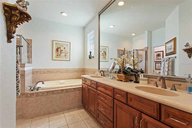 bathroom featuring vanity with extensive cabinet space, tile flooring, tiled bath, and dual sinks