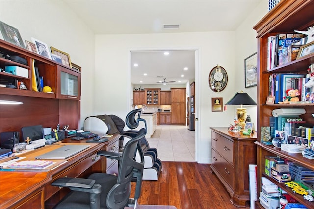 office with wood-type flooring and sink