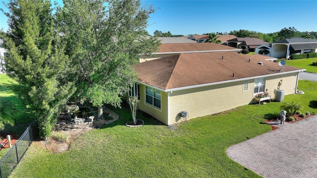 view of side of property with a lawn and central air condition unit