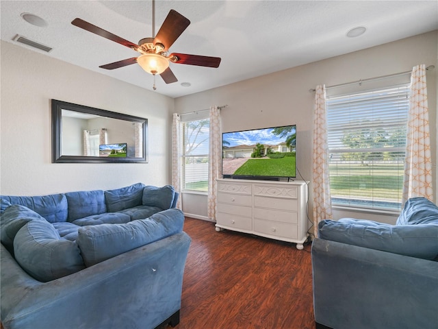 living room with ceiling fan and dark wood-type flooring