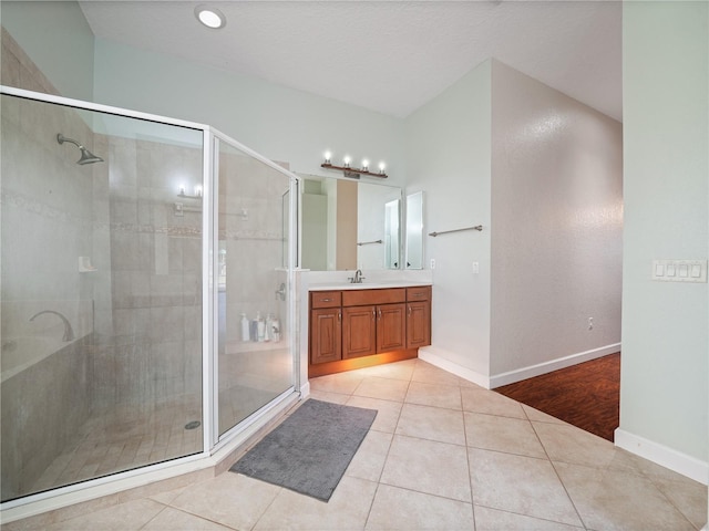 bathroom featuring a shower with door, tile flooring, and oversized vanity