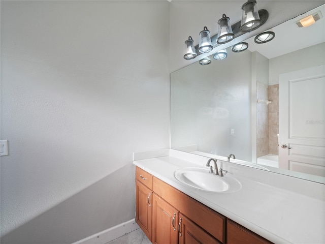 bathroom with tile floors, vanity with extensive cabinet space, and tiled shower / bath